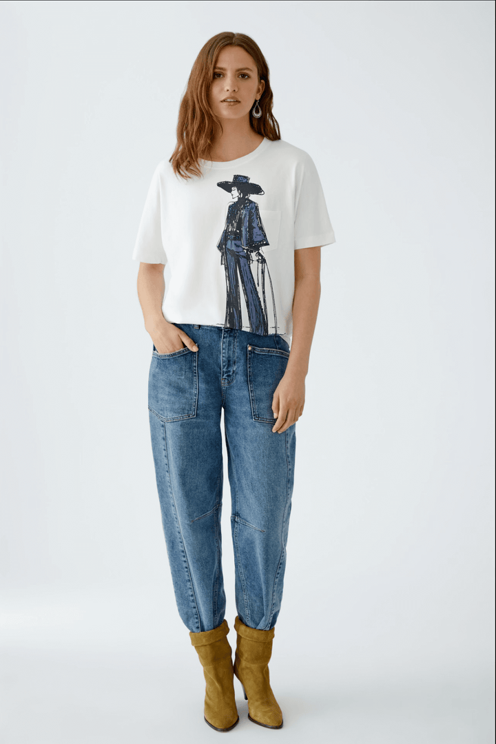 T-shirt danseur blanc avec motif dessiné à la main, porté avec un jean et des bottines jaunes.