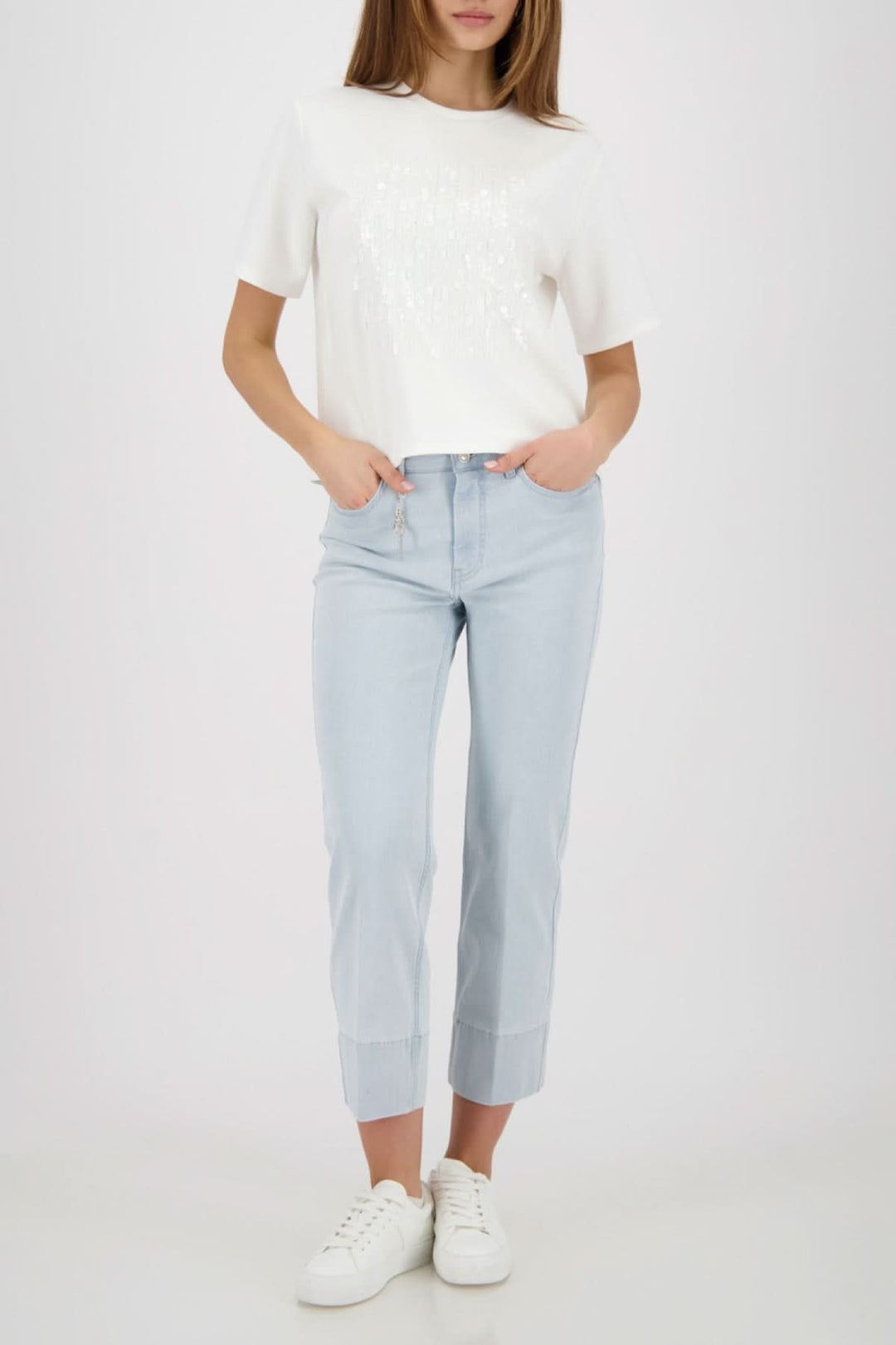 T-shirt à empiècement pailleté femme, coupe droite, manches courtes, encolure ronde, porté avec un pantalon denim clair.