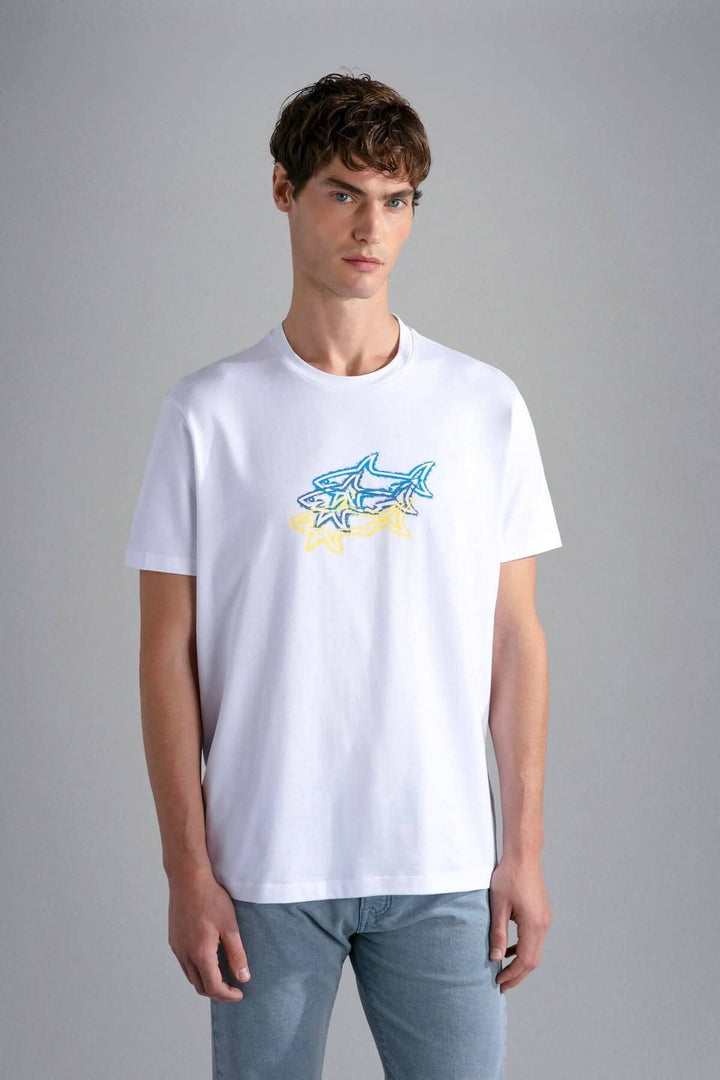 Homme portant un t-shirt imprimé avec 3 requins en bleu et jaune, en coton bio, style Paul &amp; Shark.