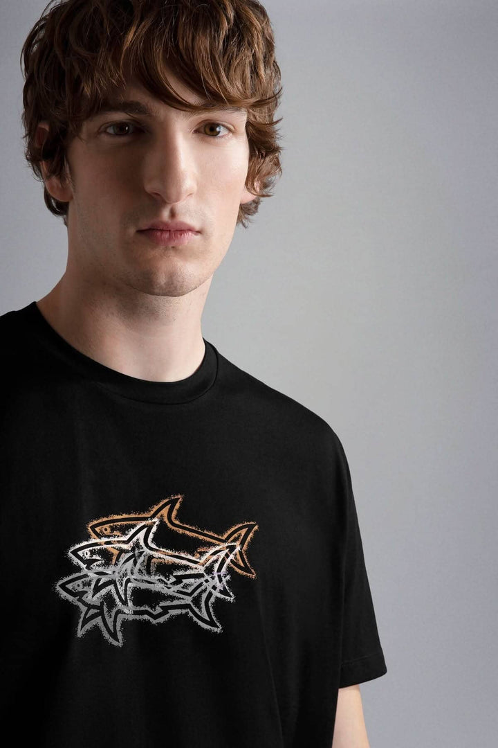 T-shirt noir avec imprimé de trois requins en relief, porté par un modèle, idéal pour l&