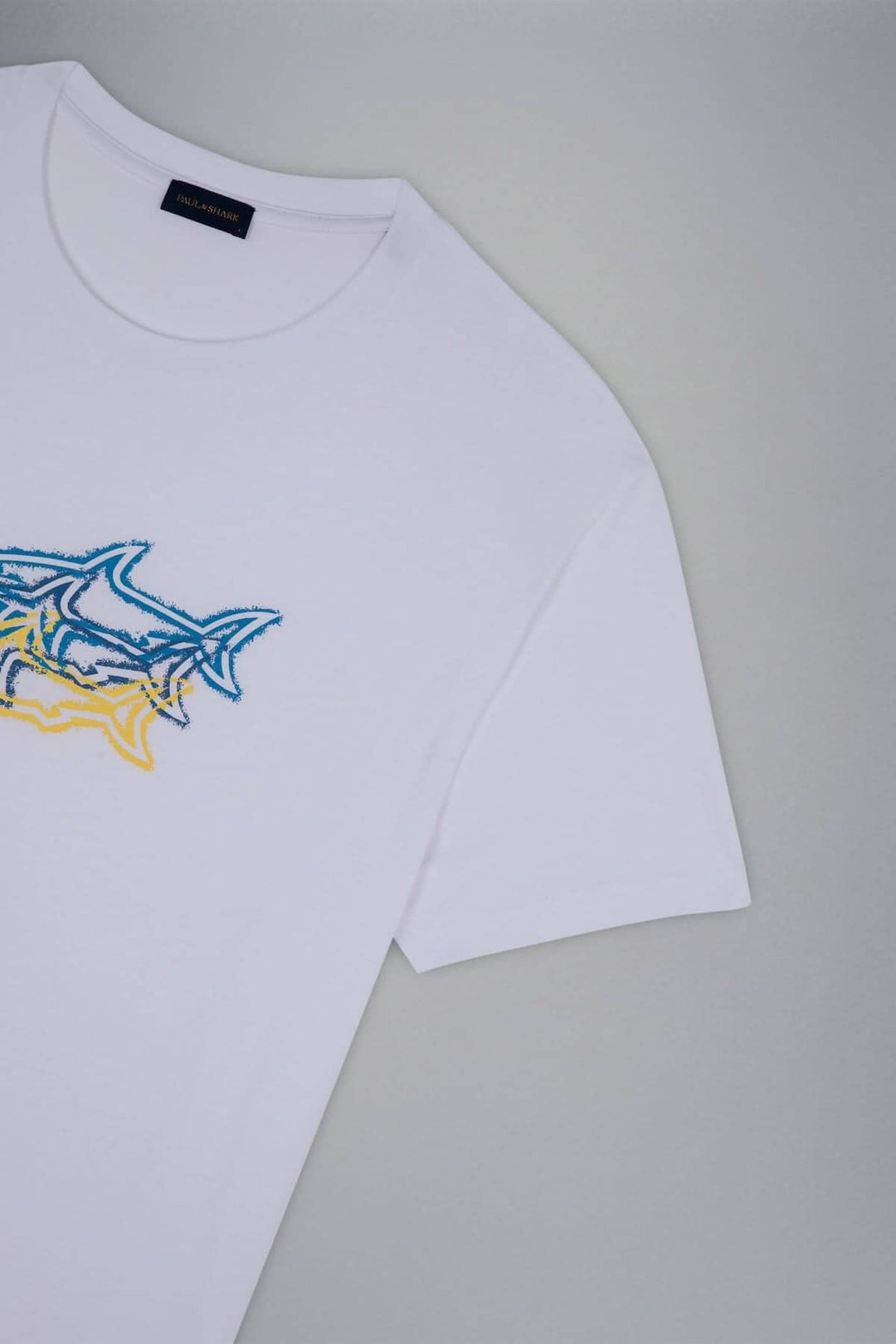 T-shirt blanc avec motif de 3 requins colorés sur le devant, fabriqué en coton biologique.