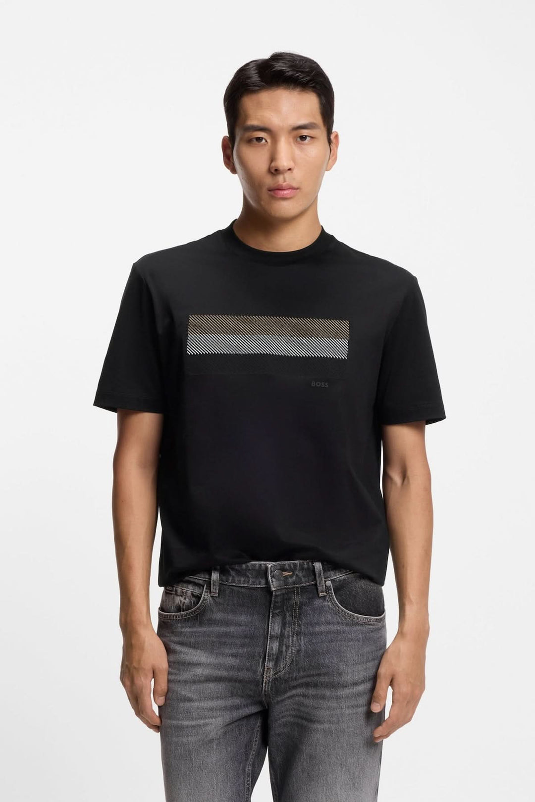 Homme portant un T-shirt à imprimé graphique minimaliste, coupe droite, manches courtes, noir, avec jean décontracté.