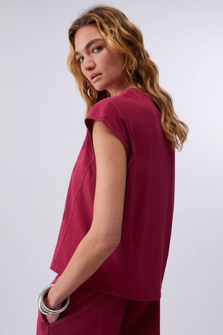Femme portant un t-shirt imprimé à manches courtes en tissu léger et fluide, style décontracté et moderne.