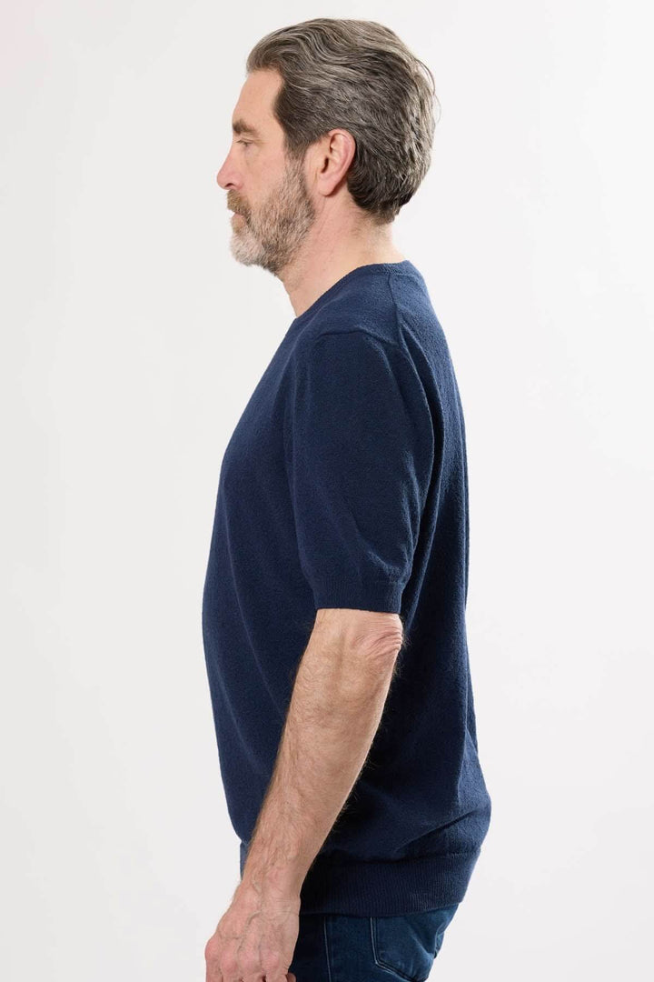 T-shirt élégant en coton biologique, coupe épurée, couleur bleu marine, porté par un homme, profil latéral.