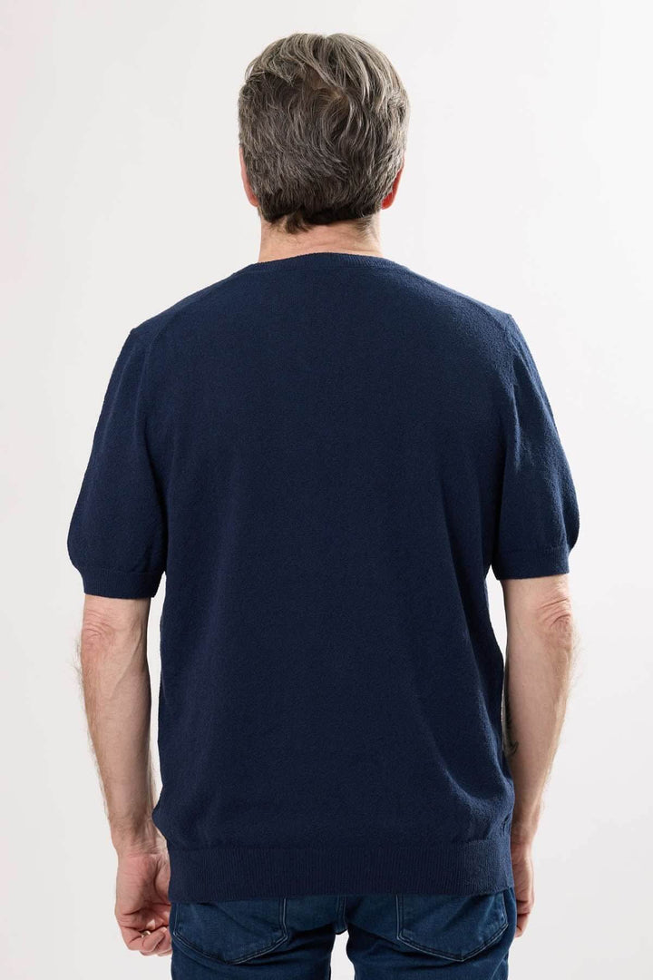 Homme vu de dos portant un t-shirt élégant en coton, couleur marine, style décontracté.