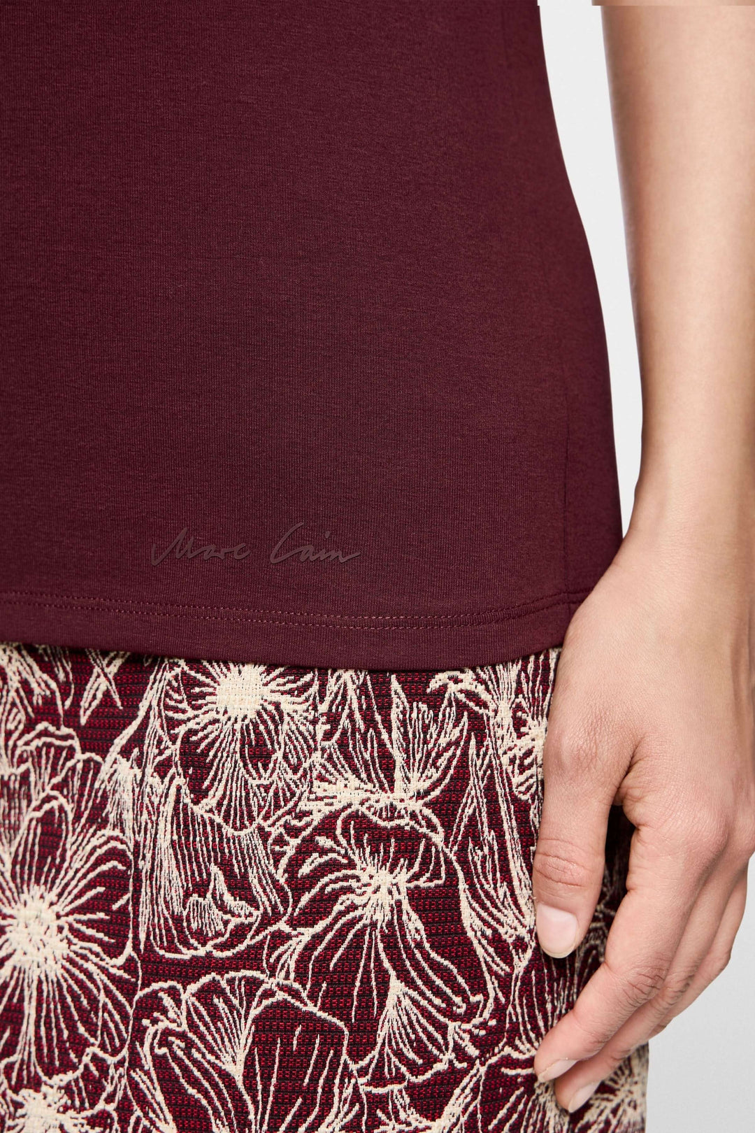 T-shirt manches courtes bordeaux détail avec jupes à motifs floraux, style élégant et décontracté.