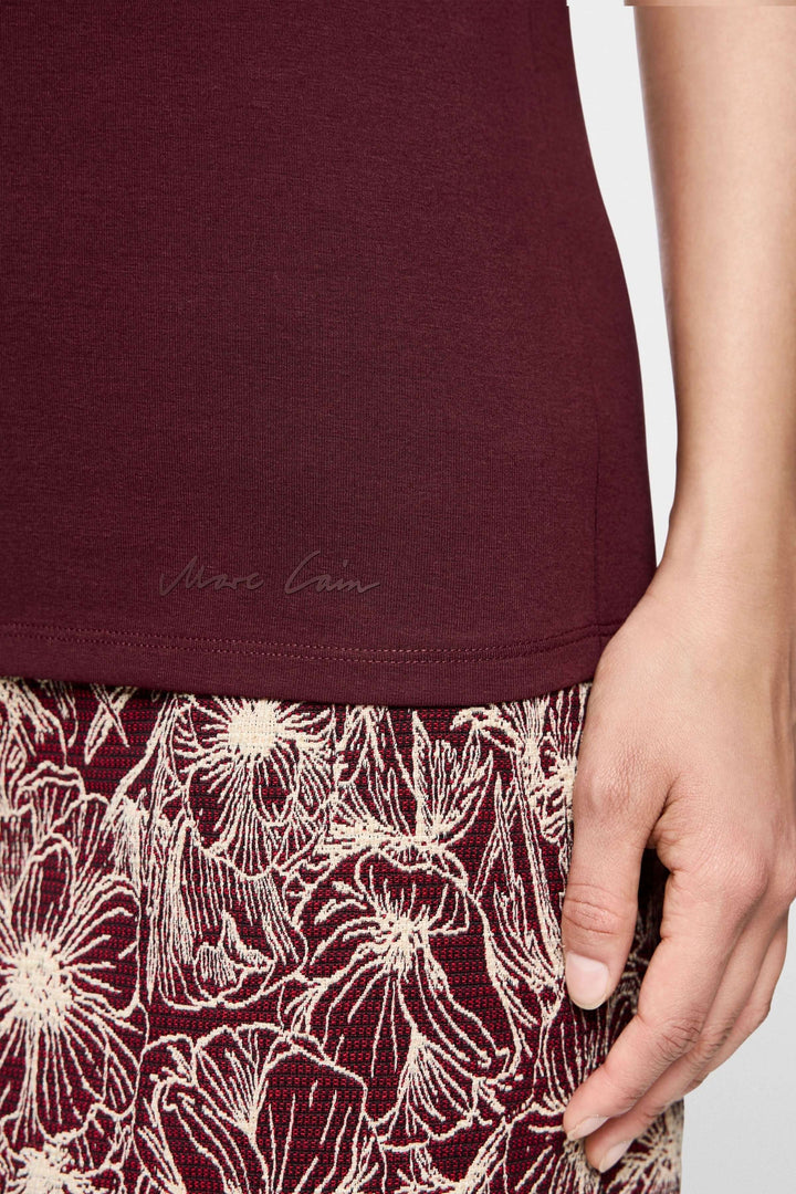 T-shirt manches courtes bordeaux détail avec jupes à motifs floraux, style élégant et décontracté.