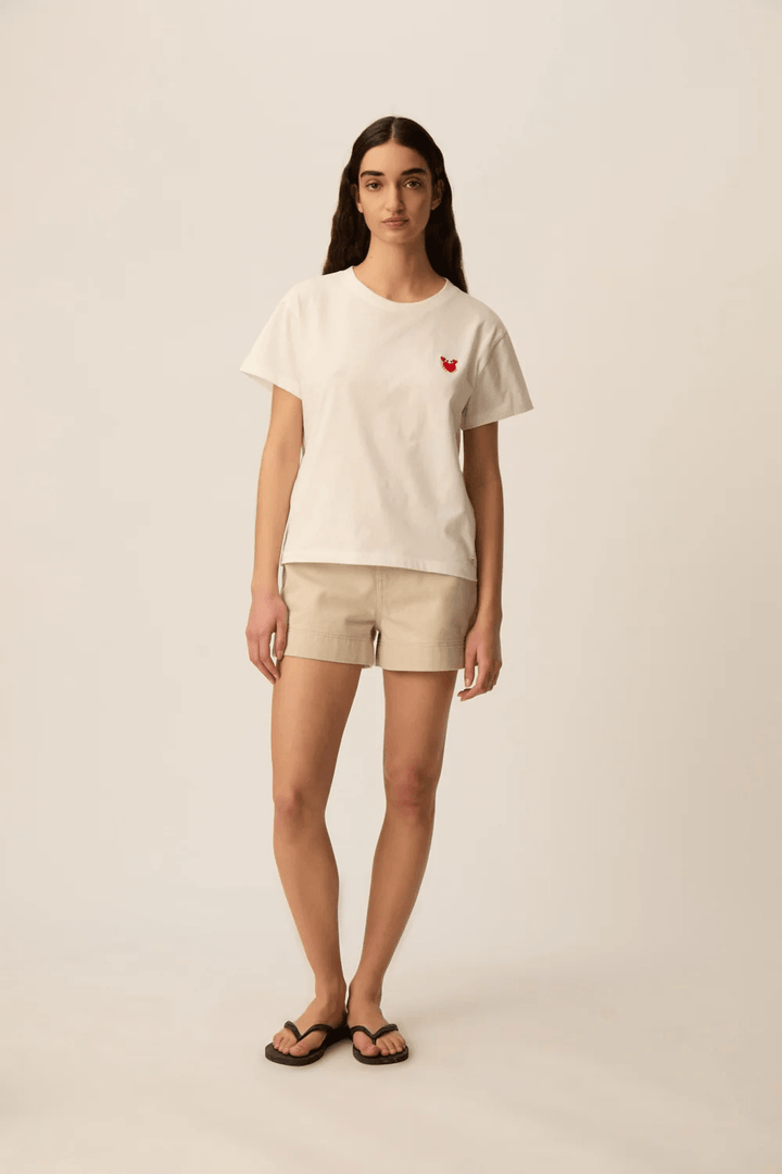 Femme portant un T-shirt à manches courtes col rond coupe classique avec détail discret sur la poitrine.