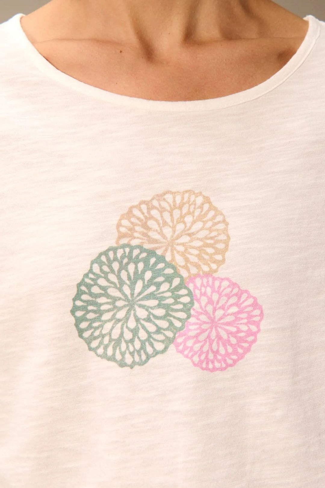 T-shirt à manches courtes coupe décontractée avec design floral multicolore sur le devant, encolure ronde et tissu léger.