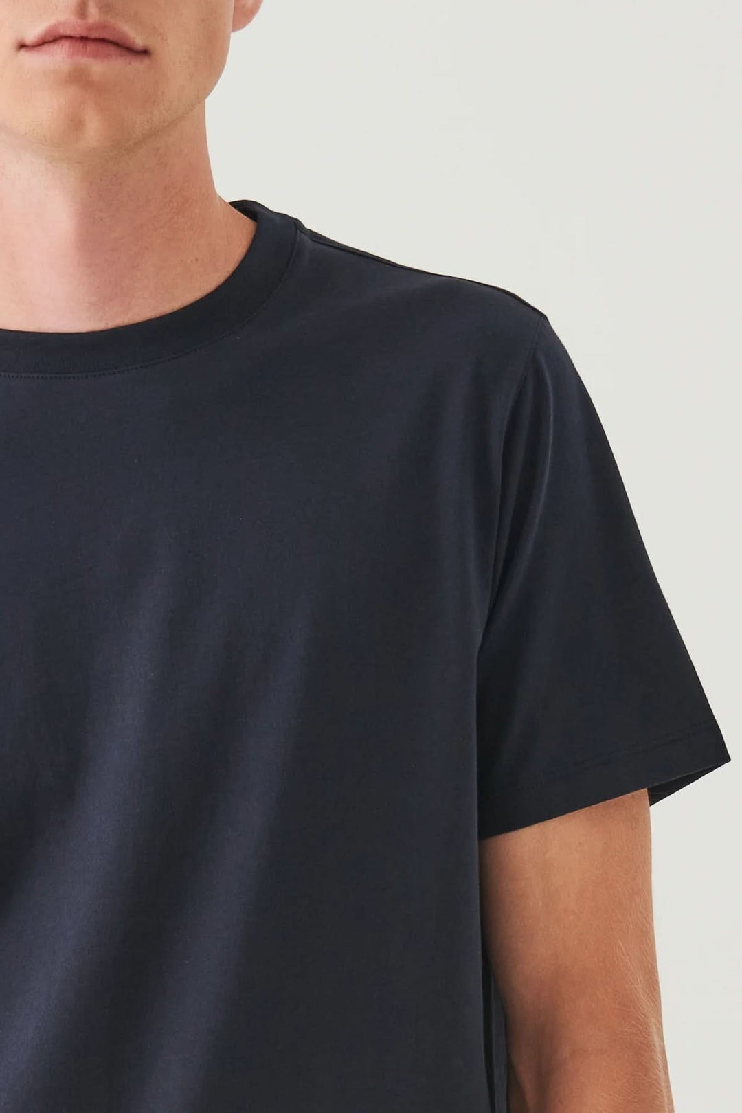 T-shirt minimaliste col rond en jersey lisse, style épuré avec coupe droite et manches courtes.