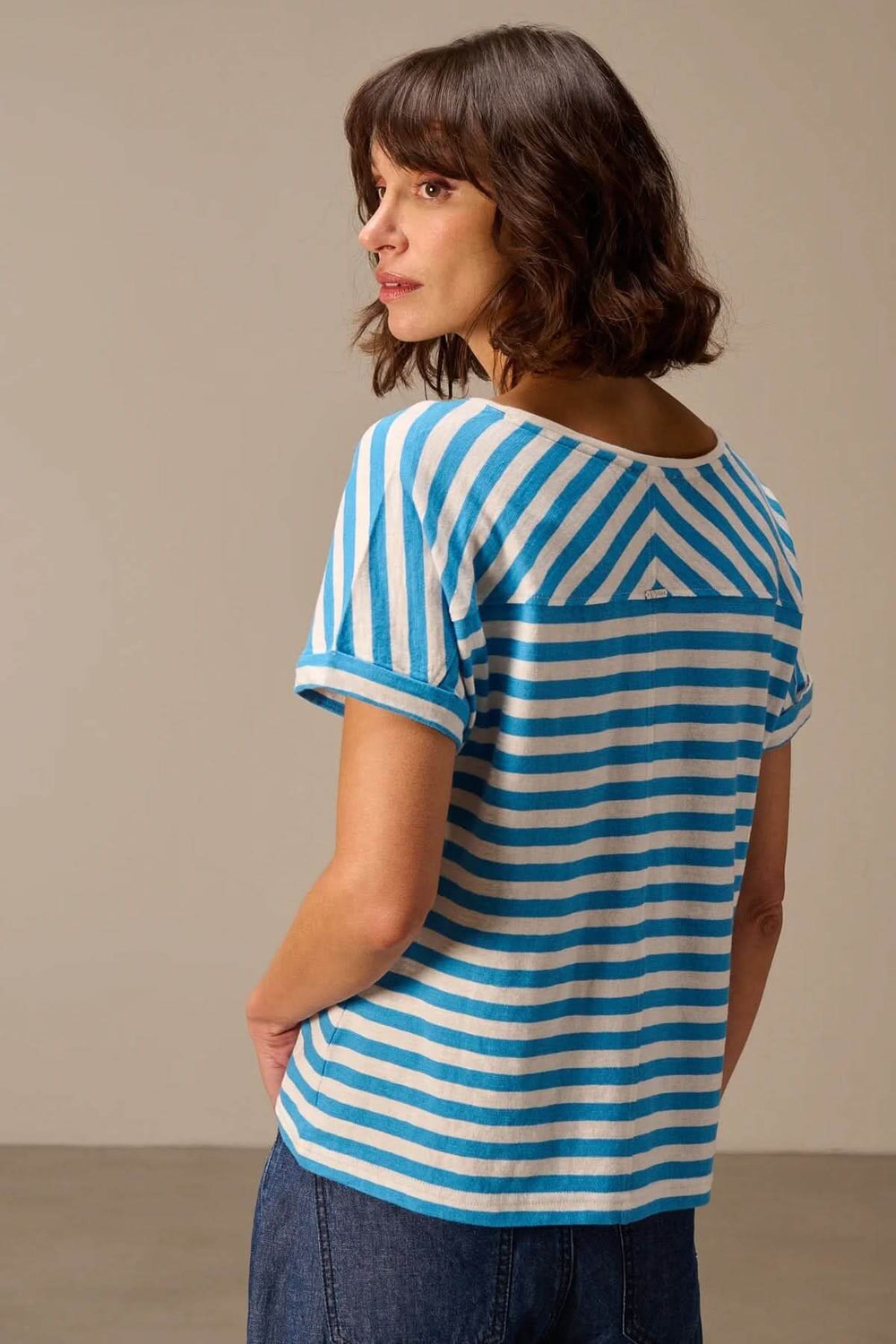 Femme portant un t-shirt rayé à manches courtes coupe décontractée, vue de dos, alliant style casual et confort diurne.