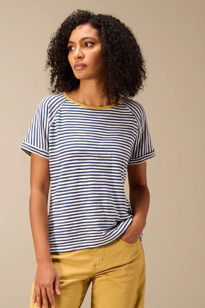Femme portant un T-shirt rayé manches courtes style raglan avec encolure ronde contrastante, manches retroussées et coupe décontractée.