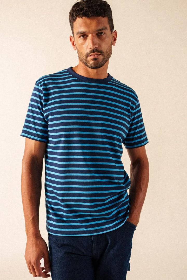 Homme portant un t-shirt à rayures classique bleu et noir, style décontracté avec manches courtes et encolure arrondie.