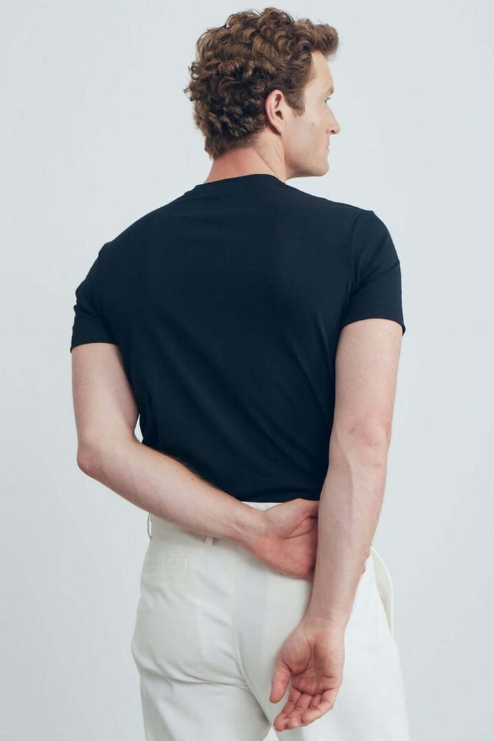 T-shirt uni noir à col rond, vue de dos, avec coupe ajustée et finitions soignées.
