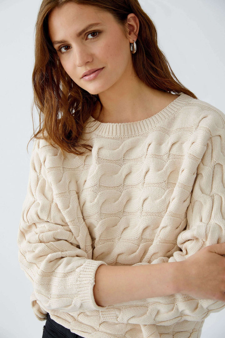 Femme portant un Tricot Sirah torsadé en coton doux avec coupe carrée et col bateau.