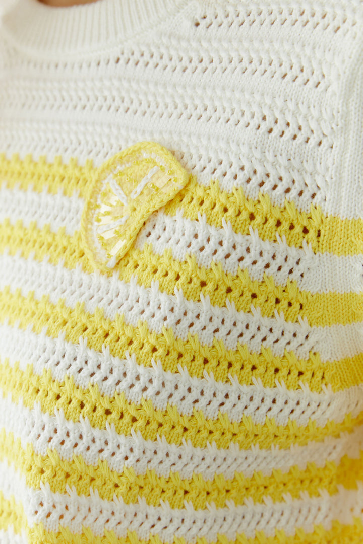 Tricot ajouré à rayures manches courtes avec motif structuré et détail distinctif à la poitrine jaune et blanc.