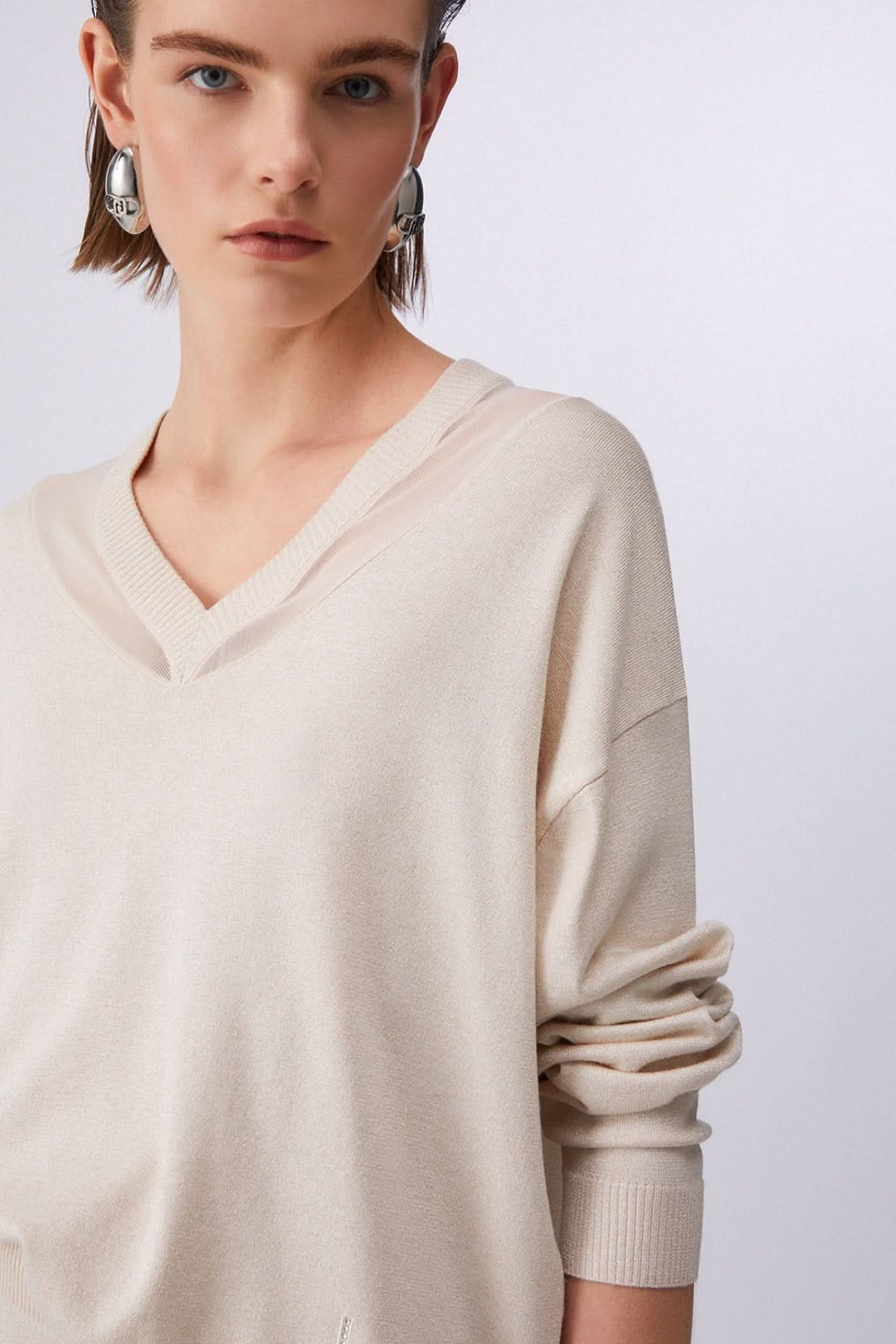 Tricot col en V à manches longues beige confortable et élégant pour un look décontracté et intemporel.