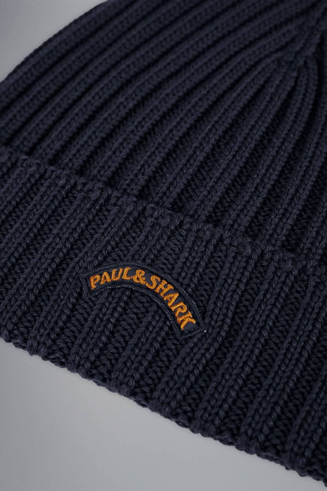 Tuque en maille côtelée bleu marine avec logo brodé Paul & Shark; style intemporel et confort optimal pour l'hiver.