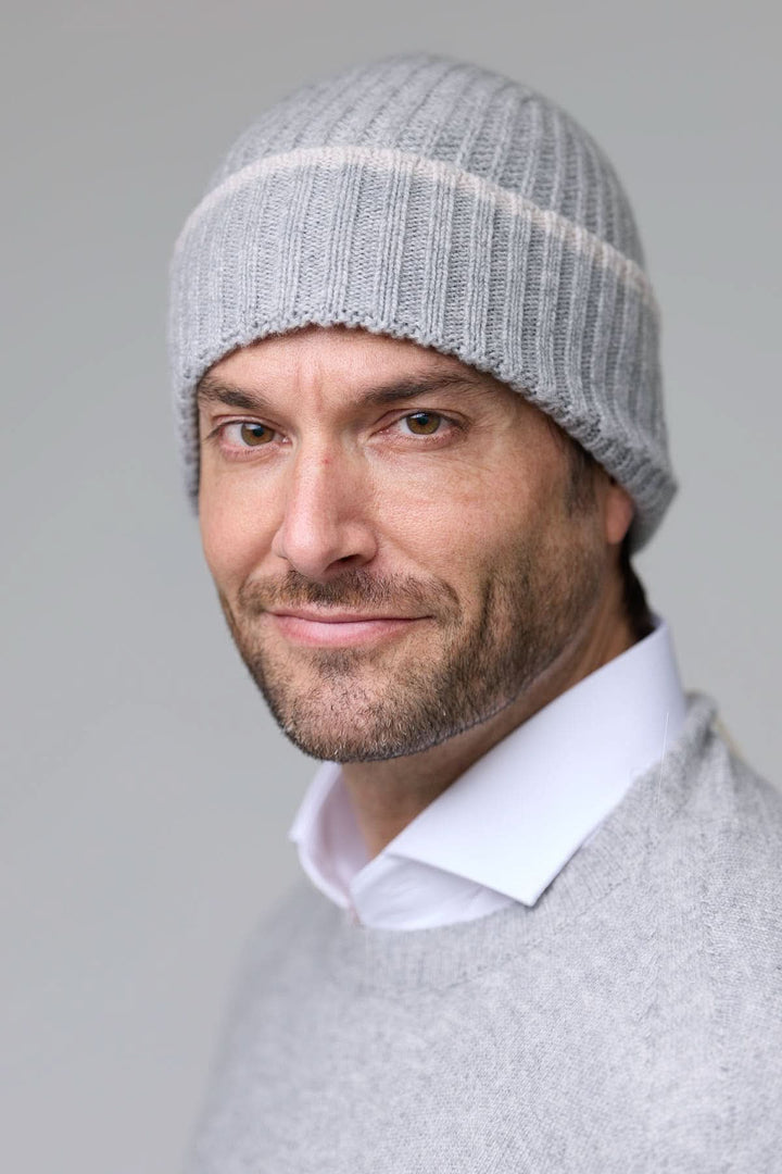 Homme portant une tuque en tricot côtelé gris clair, confortable pour les journées froides, style décontracté et polyvalent.