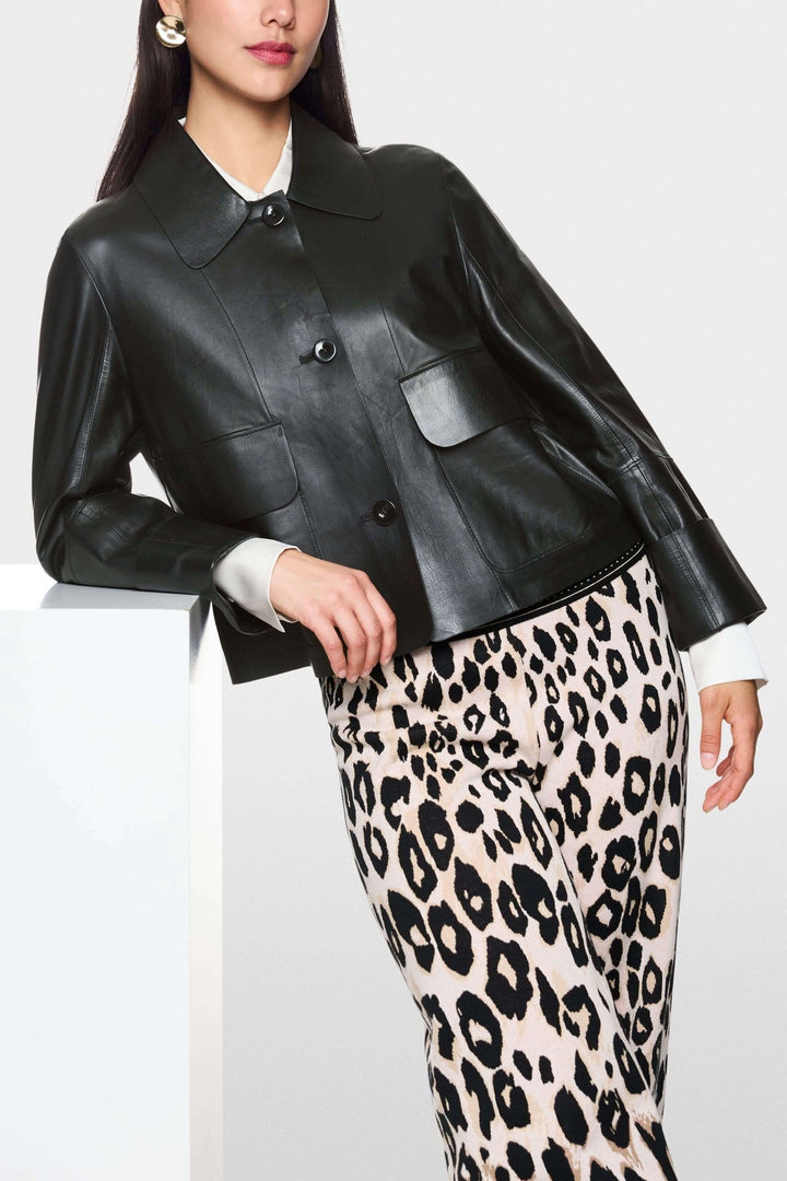 Femme portant une veste coupe moderne en cuir véritable avec col classique et grandes poches, associée à un pantalon imprimé léopard.