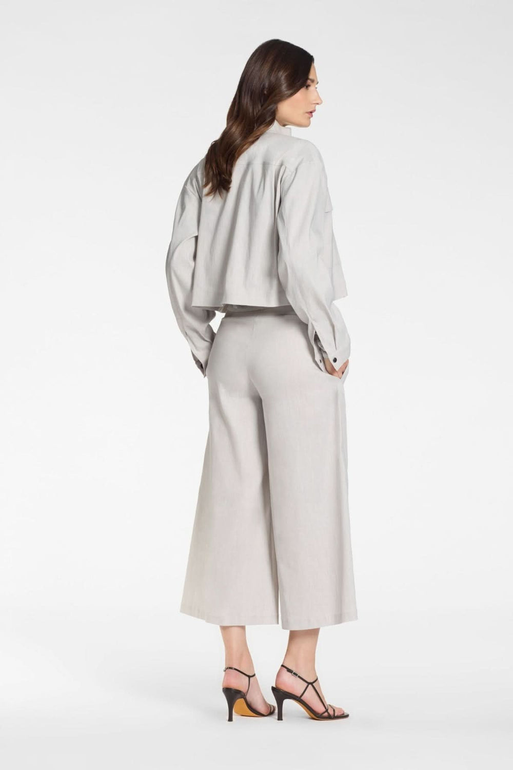 Vue arrière de la veste courte à zip col montant, parfaite pour un look moderne. Décris moi le produit en français. Mode féminine élégante.