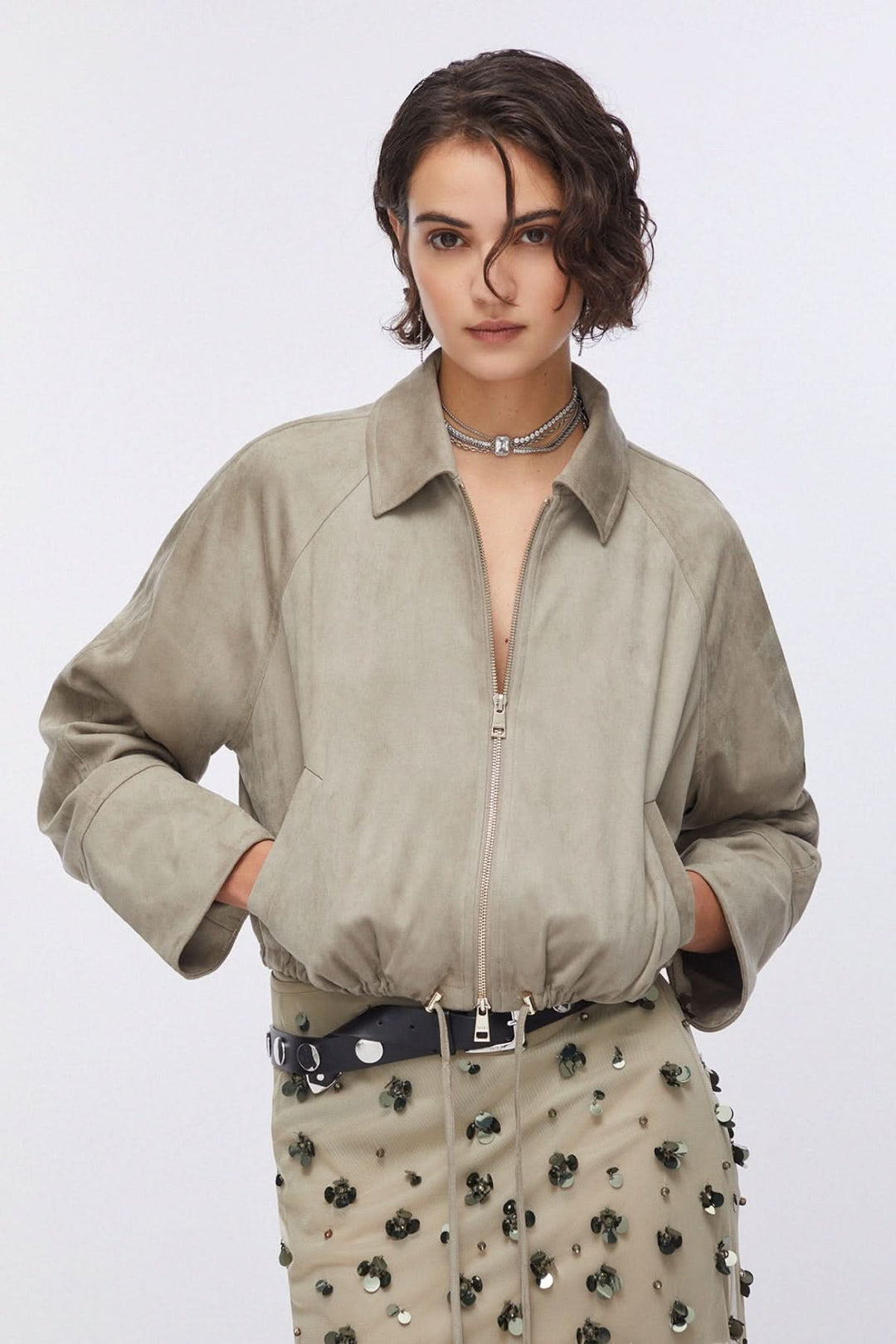 Femme portant une veste courte zippée à col chemise avec un design épuré et moderne, idéale pour la mi-saison.