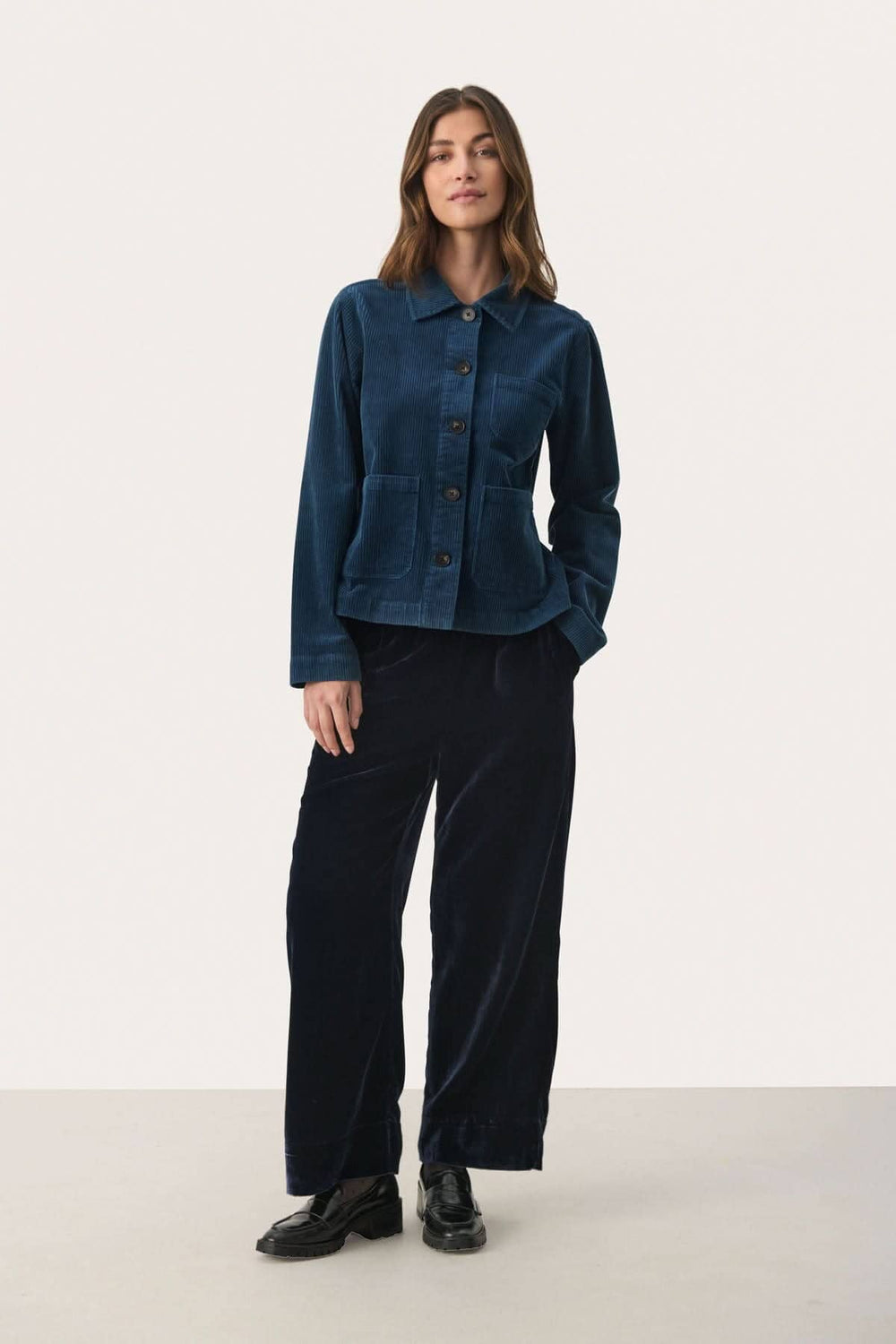 Veste en corduroy bleu marine avec coupe moderne, manches longues et boutons contrastants.