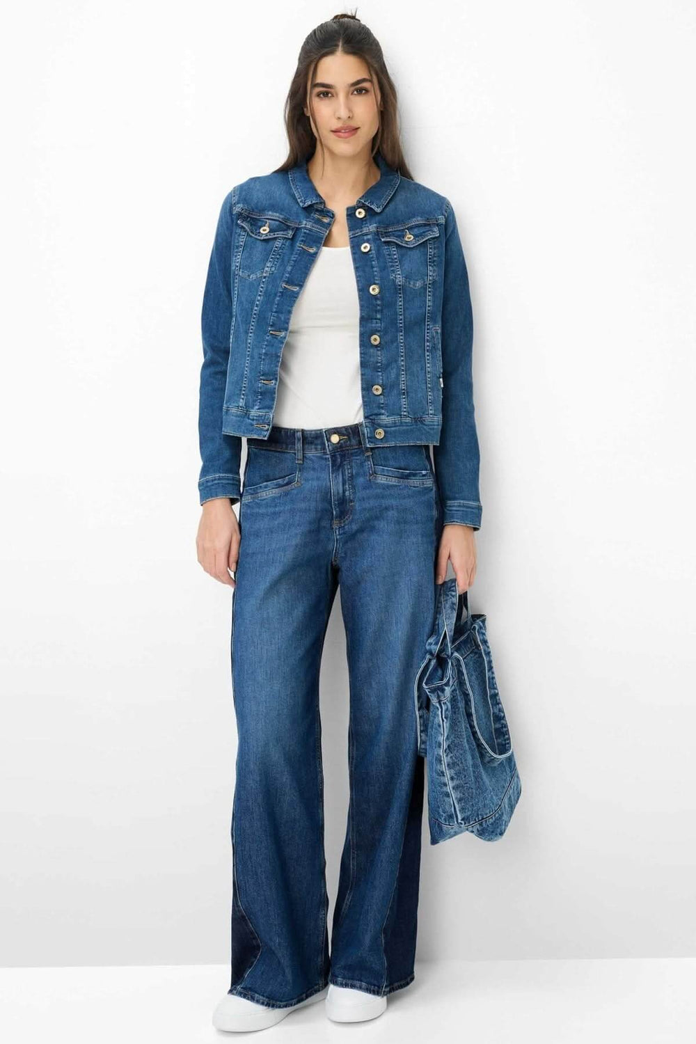 Femme portant une veste en denim ajustée MIAMI avec jean et top blanc, tenue décontractée et moderne.