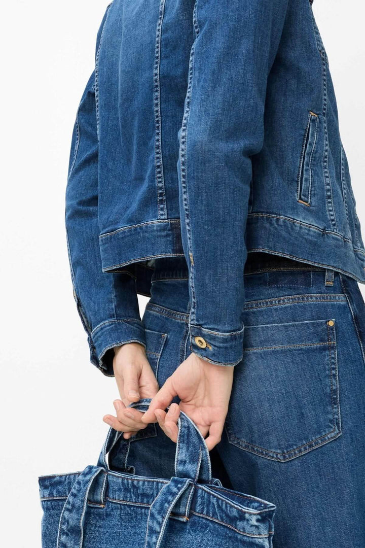 Veste en denim ajustée MIAMI pour garder un style élégant et moderne, avec détails métalliques, sur silhouette féminine.