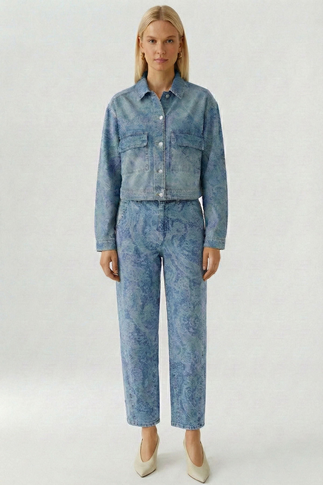 Veste en jean imprimée avec motif cachemire subtil, coupe raccourcie et moderne, portée seule ou avec pantalon assorti.