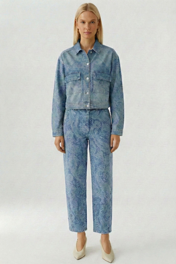 Veste en jean imprimée avec motif cachemire subtil, coupe raccourcie et moderne, portée seule ou avec pantalon assorti.