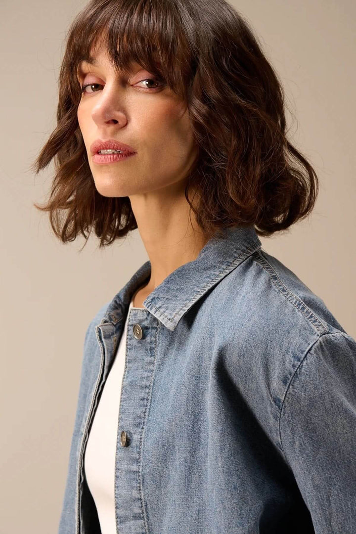 Femme portant une veste en jean à manches longues en denim souple et confortable.