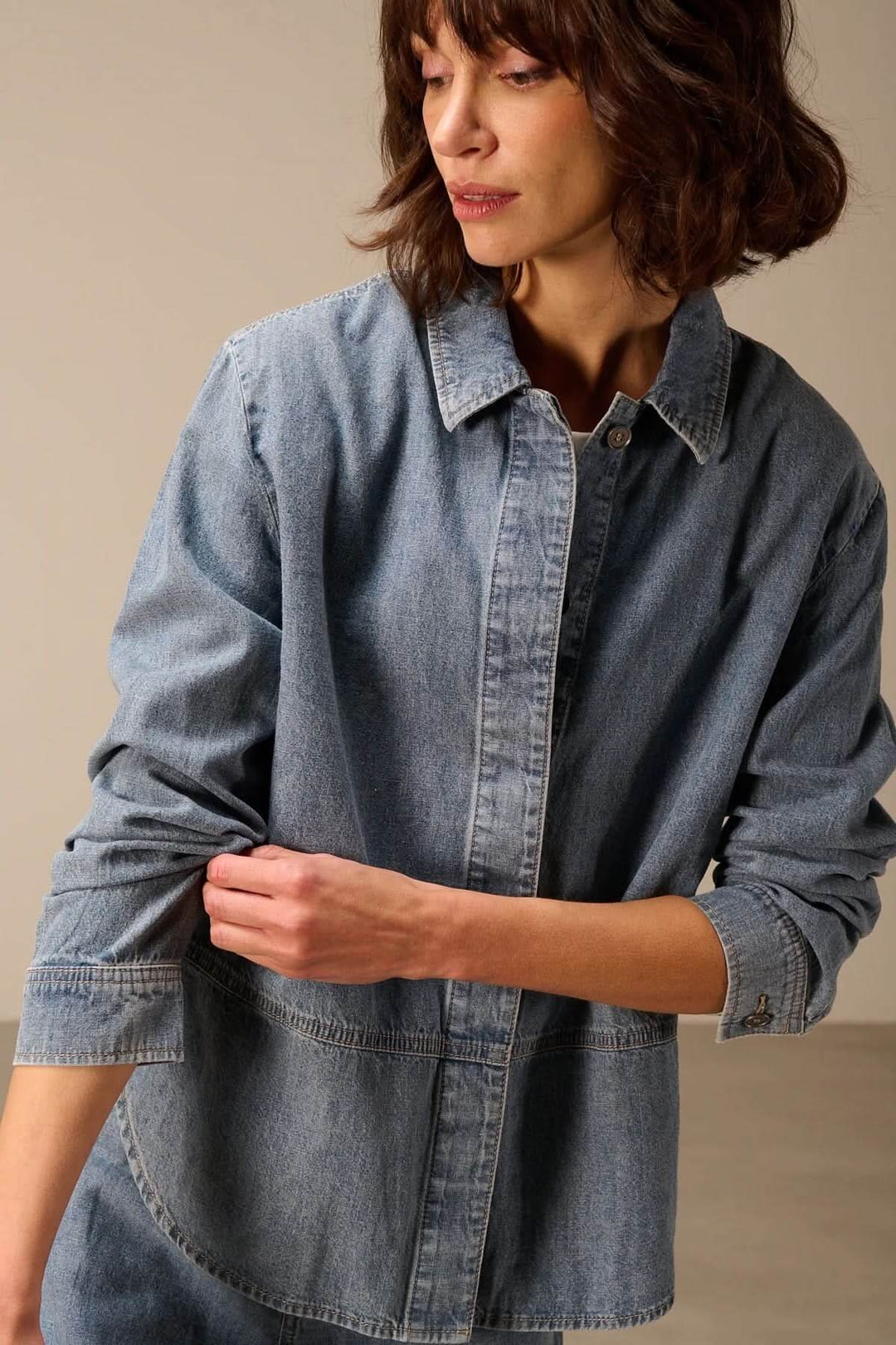 Veste en jean à manches longues portée par une femme, mettant en valeur son denim souple et sa silhouette décontractée.