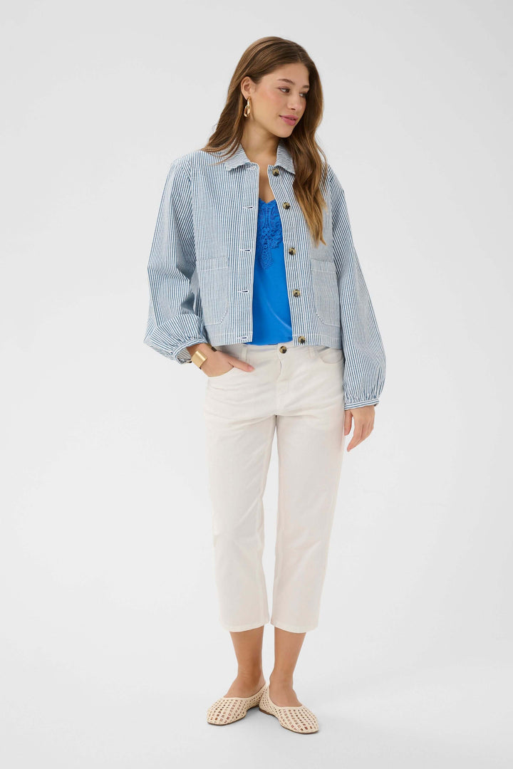 Modèle portant une Veste légère rayée à boutons avec une tenue décontractée, alliant style moderne et intemporel.