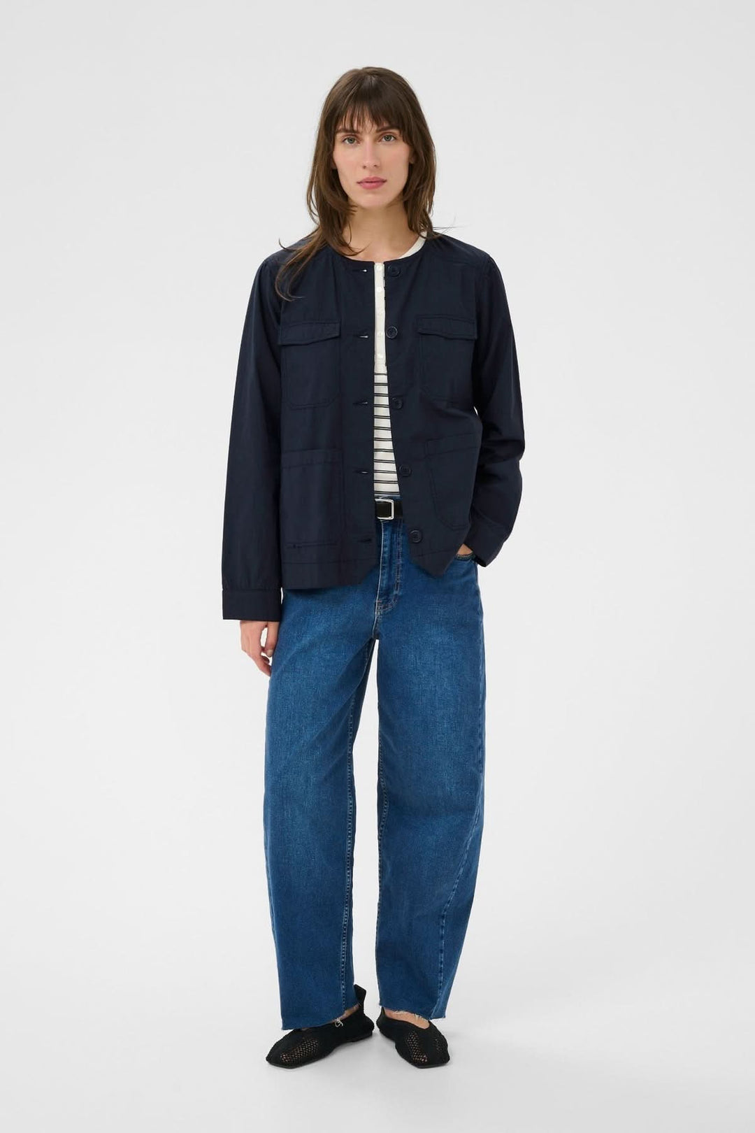Veste légère utilitaire Aziza noire portée avec tenue décontractée, coupe droite et col rond, idéale pour toute occasion.