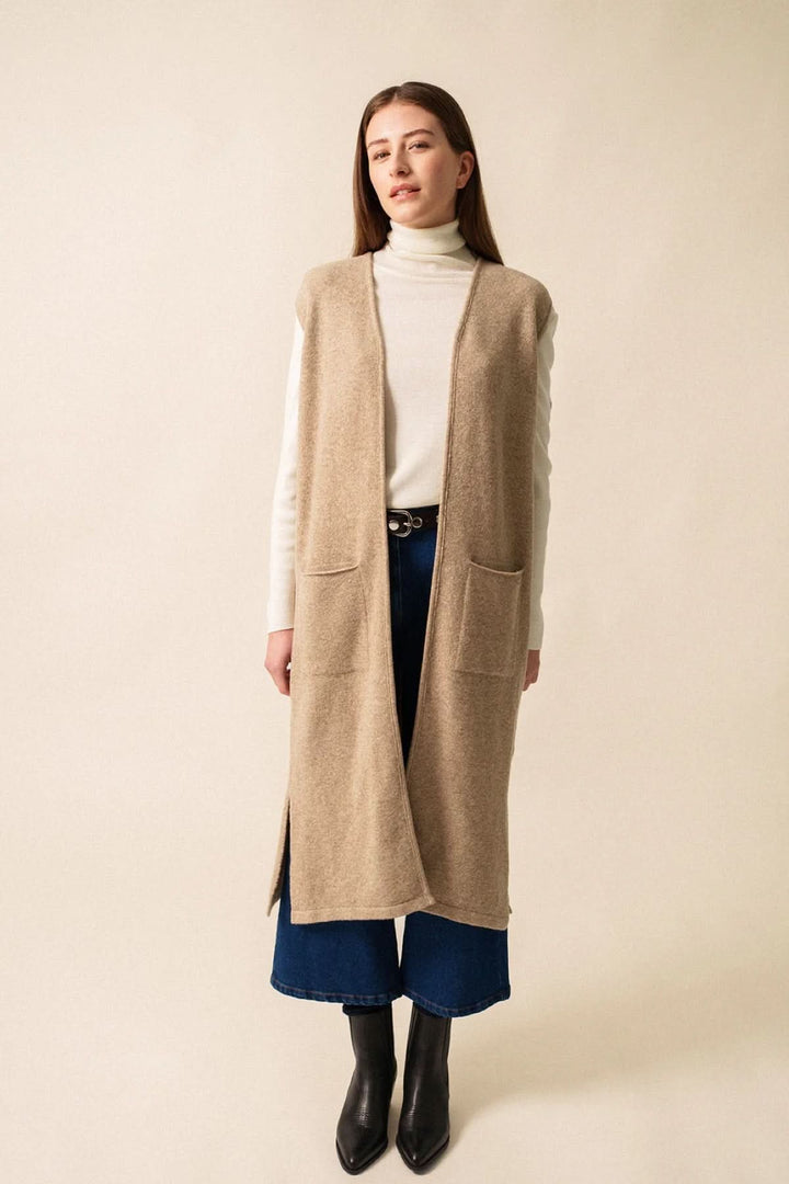 Veste longue Geneve sans manches beige, style moderne avec poches plaquées, parfaite pour un look casual chic.