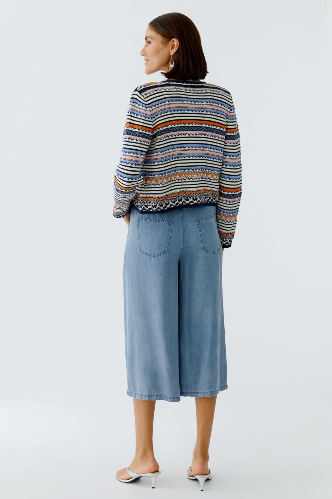 Femme portant une Veste tricot à motifs jacquard boutonnée élégante et originale, vue de dos, avec des motifs raffinés et colorés.