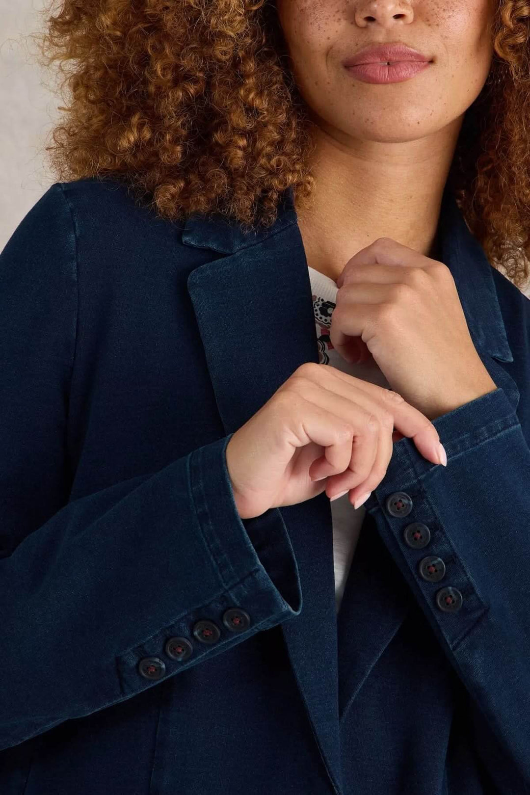 Veston décontracté en denim bleu, coupe droite, avec col tailleur classique et boutons distinctifs.