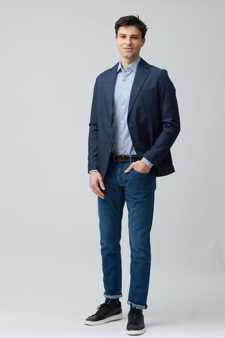 Homme portant un veston en coton et lin extensible bleu avec une chemise claire, tenue élégante et décontractée.