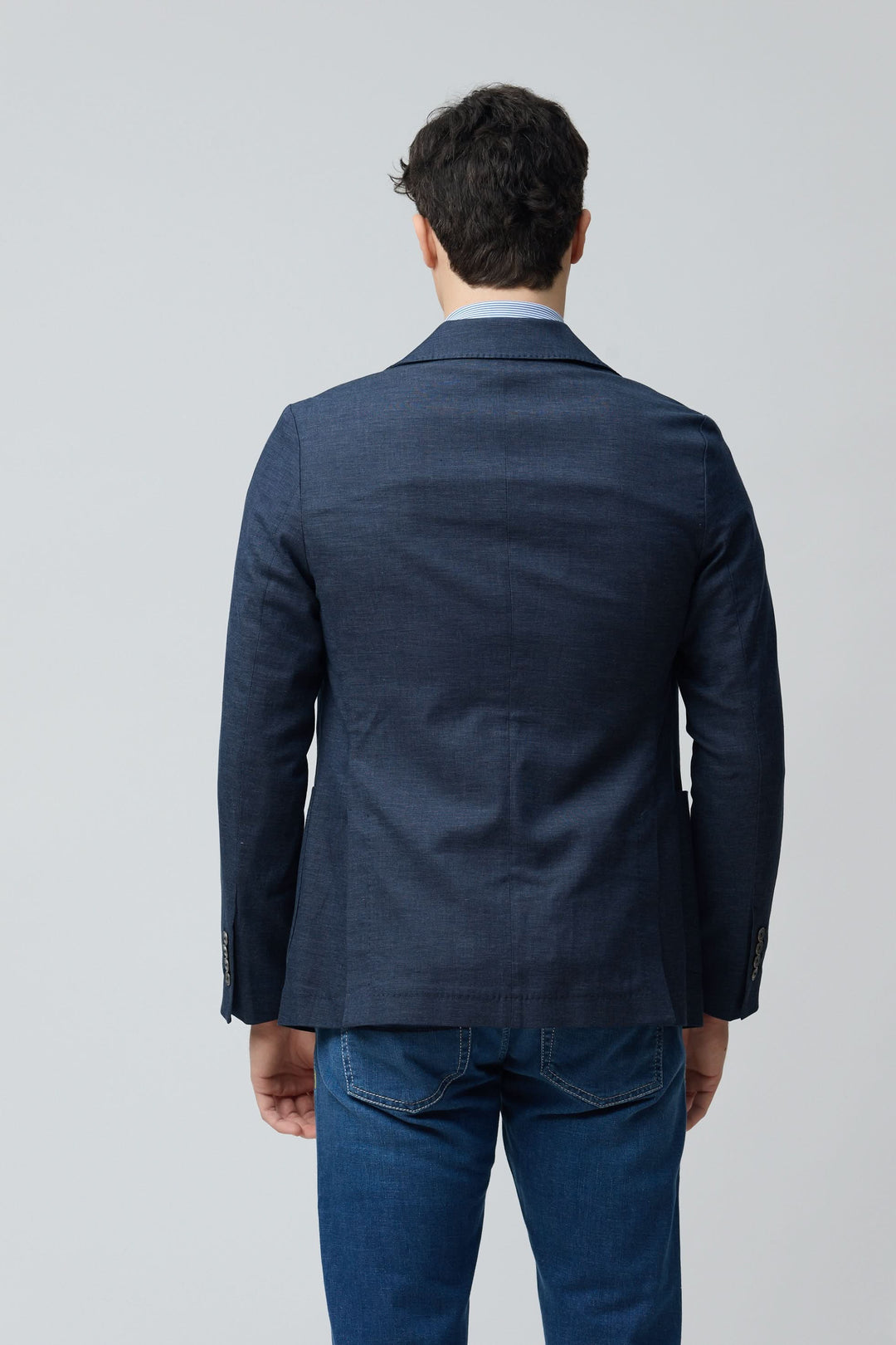 Homme portant un veston en coton et lin extensible avec une coupe ajustée vue de dos, idéal pour un style moderne et confortable.
