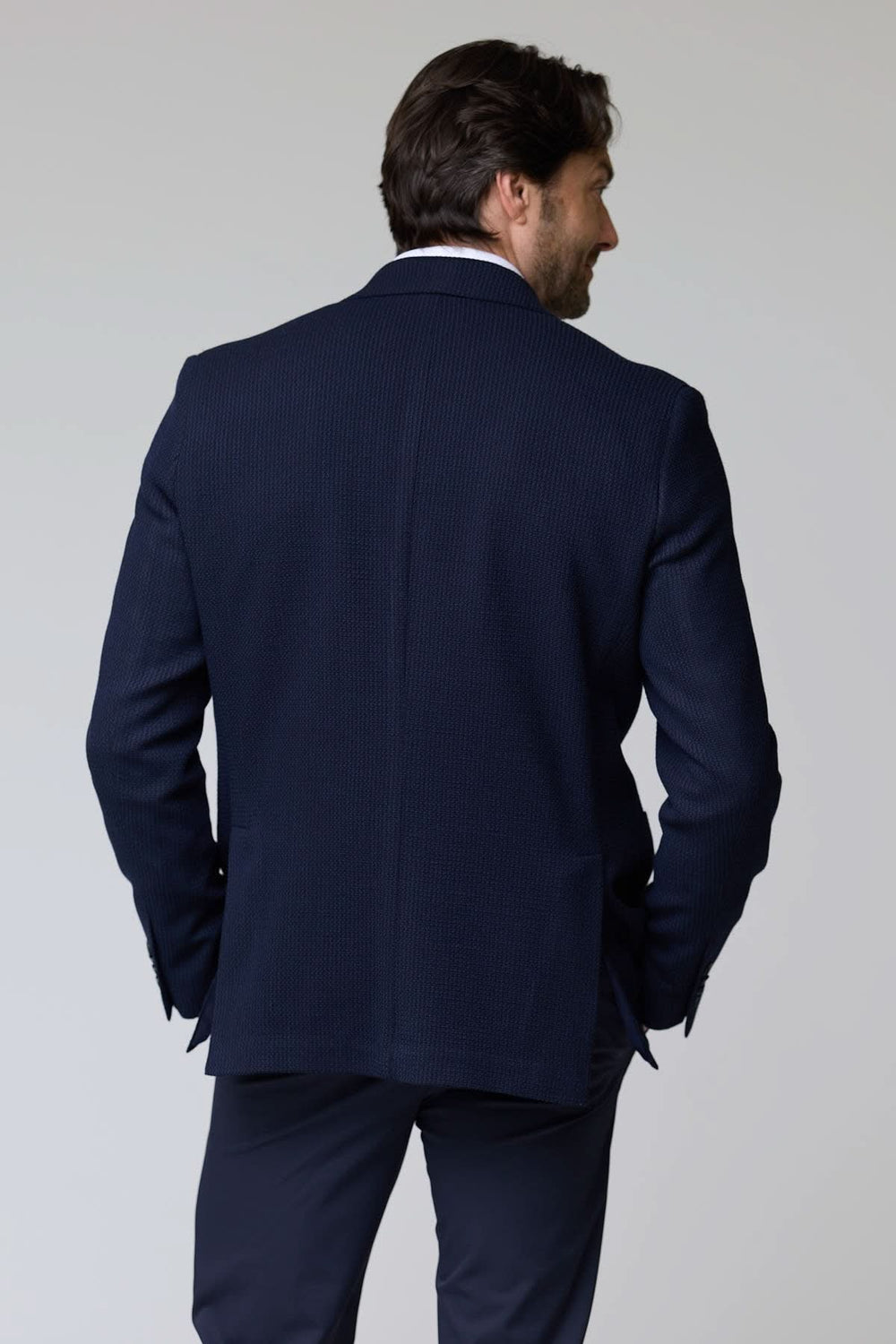 Veston en tricot structuré élégant et confortable, vu de dos, avec un design moderne et une coupe semi-ajustée.