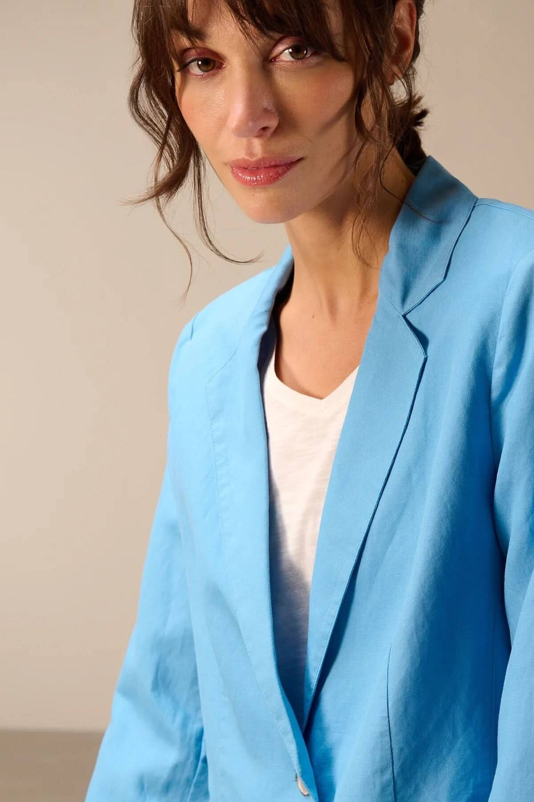 Femme portant un veston léger à coupe droite bleu, idéal pour un style élégant et moderne, avec un col tailleur classique et fermeture boutonnée.