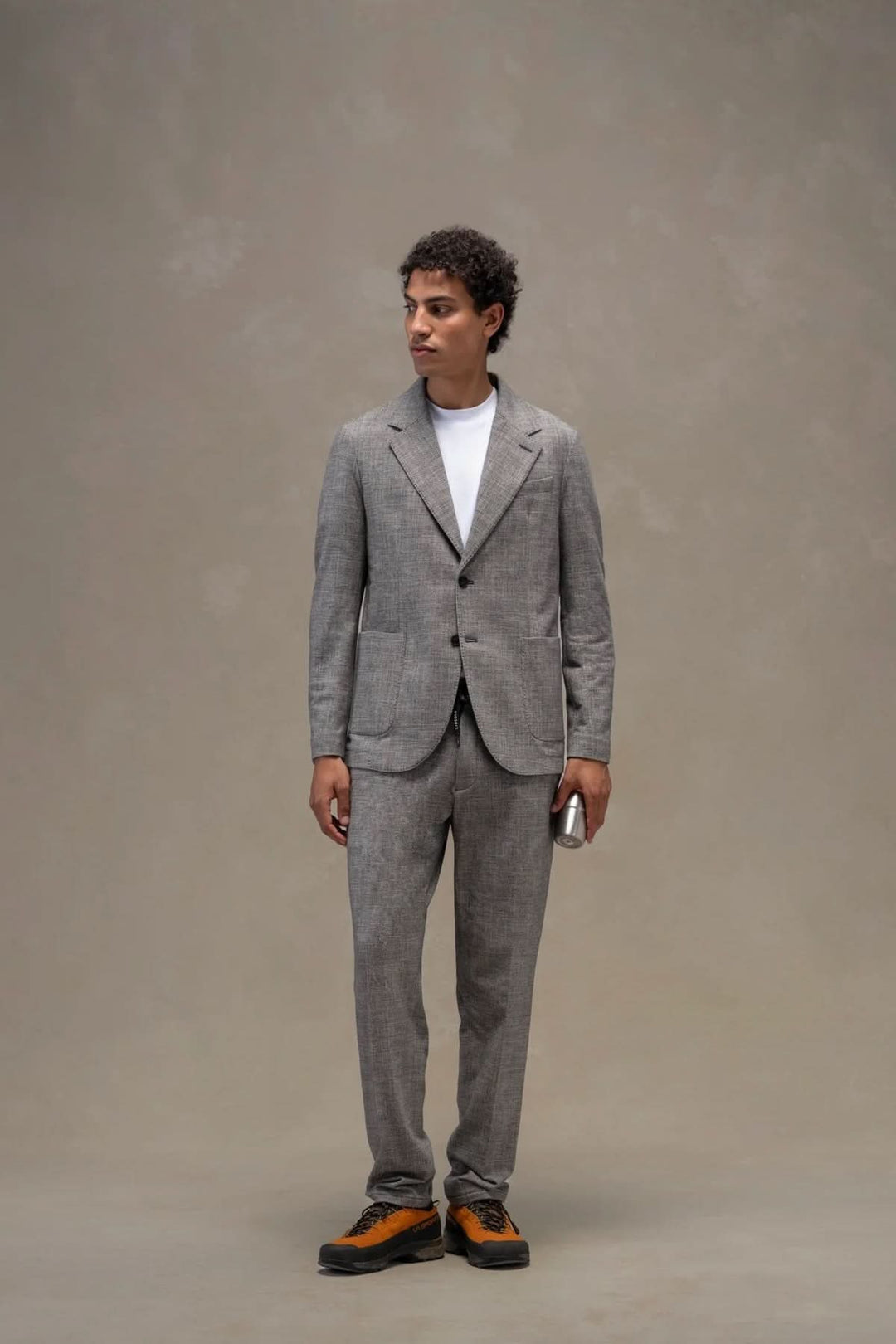 Veston texturé porté par un homme, veste en polaire imprimée avec col à revers et fermeture à boutons en corne, coupe élégante.