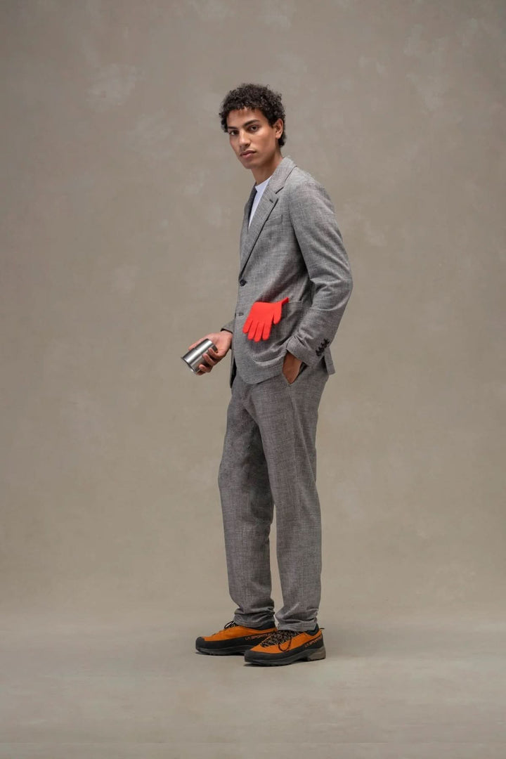 Veston texturé en laine, homme élégant en costume gris avec des gants rouges, accessoire moderne et stylé. Mode masculine sophistiquée.