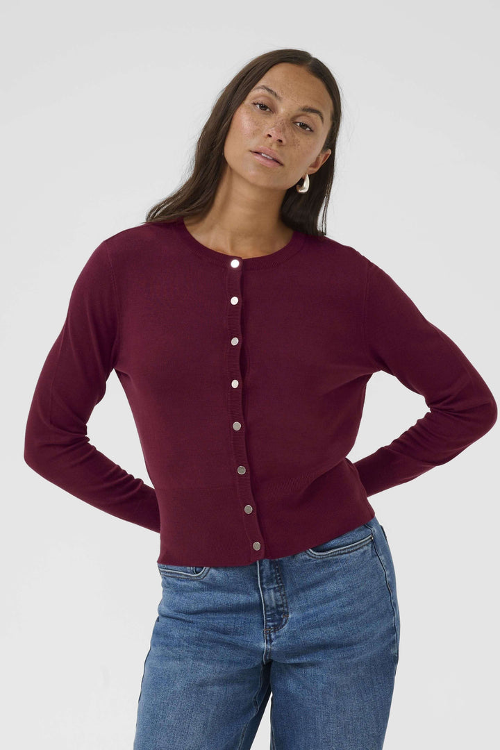 Femme portant le Cardigan Lizza classique à encolure ronde et boutons, coupe ajustée, couleur bordeaux, sur un fond blanc.