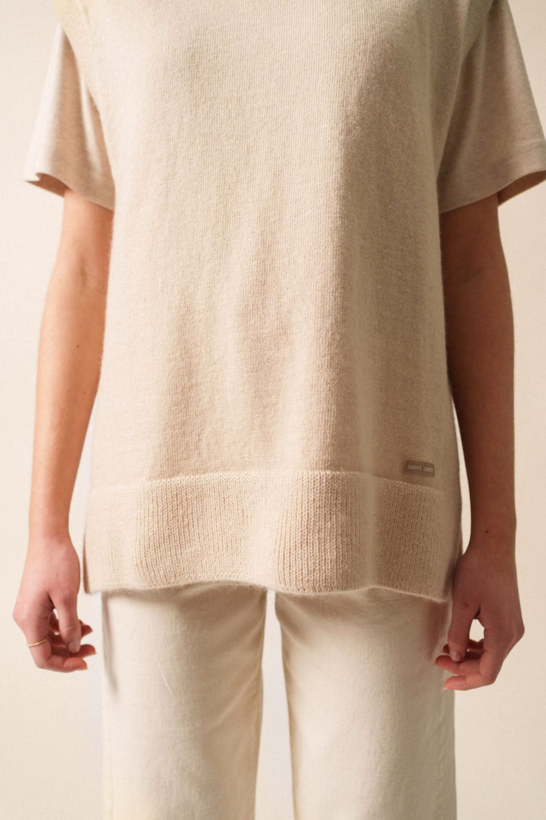 Veste en jersey beige avec côtes latérales, col boutonné et fentes, stylée avec pantalon assorti.