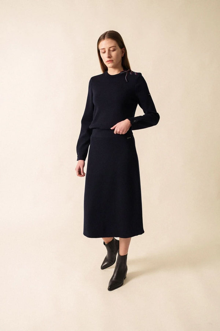 Chandail en maille à détail nœud sur l’épaule, femme portant une tenue élégante et féminine, parfait pour des journées fraîches.