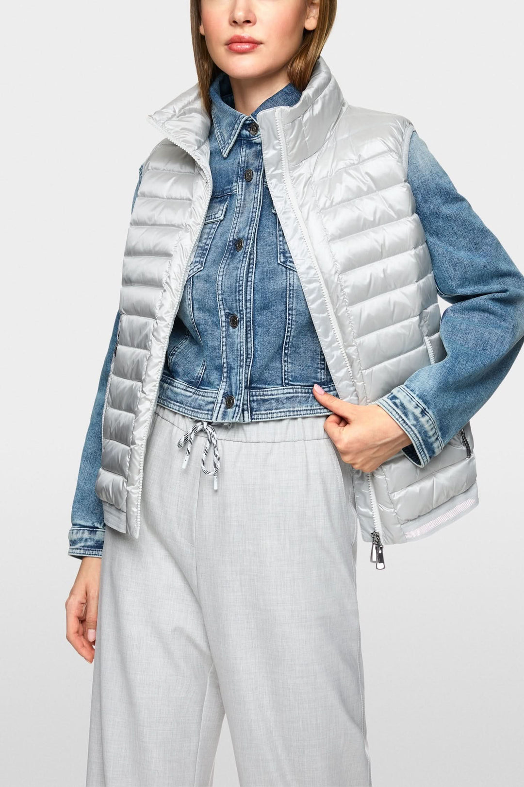 Veste matelassée sans manches en tissu recyclé, alliant confort et style moderne, portée avec un jean.