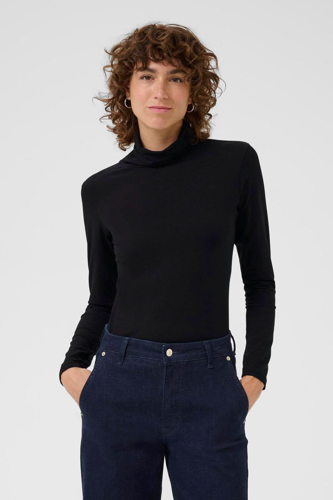 Femme portant un Col roulé Efinas noir, manches longues, coupe ajustée, élégance et confort. Idéal pour superposition ou porter seul.