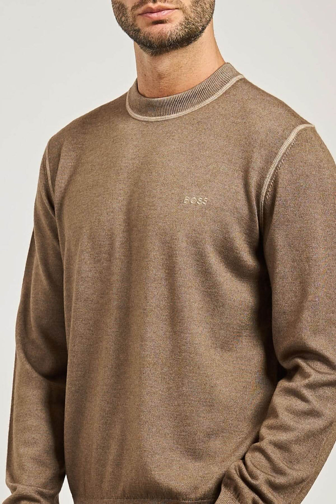 Homme portant un chandail en laine vierge à col rond BOSS Orange, confortable et léger, avec finitions côtelées.